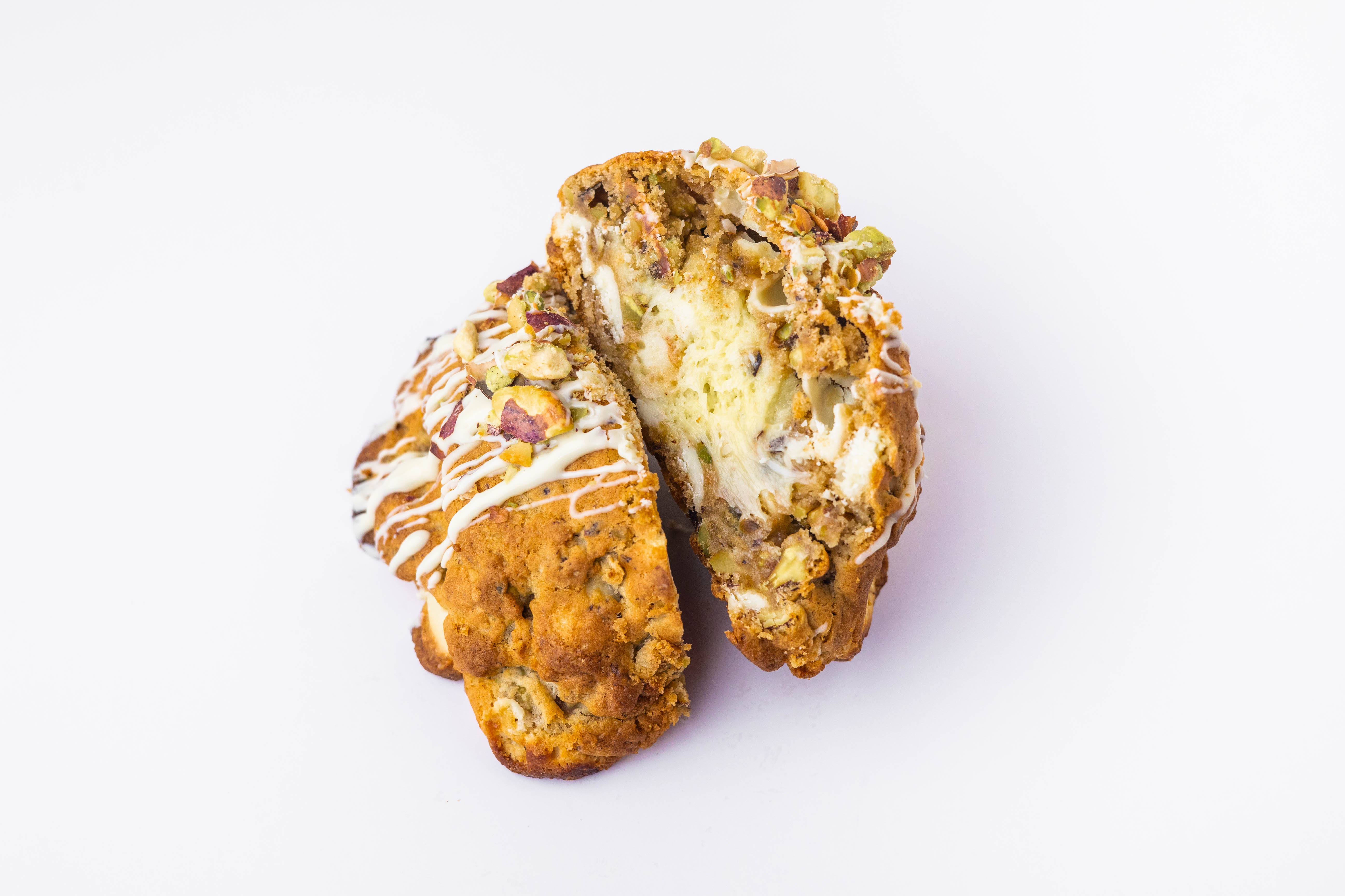 A pistachio-filled Bocados Grand Cookie cut open on a white background